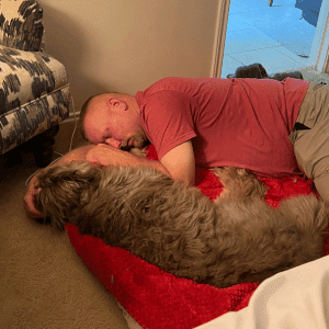 dog walker from Animal Admiration Pet care laying with a dog