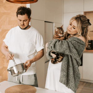 couple with cat cooking cat food