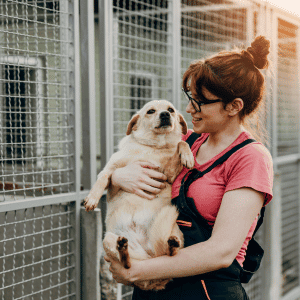 shelter volunteer with a dog in her arms