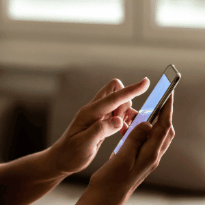 person on smart phone - How We Handle Winter Inclement Weather at Animal Admiration Pet Care